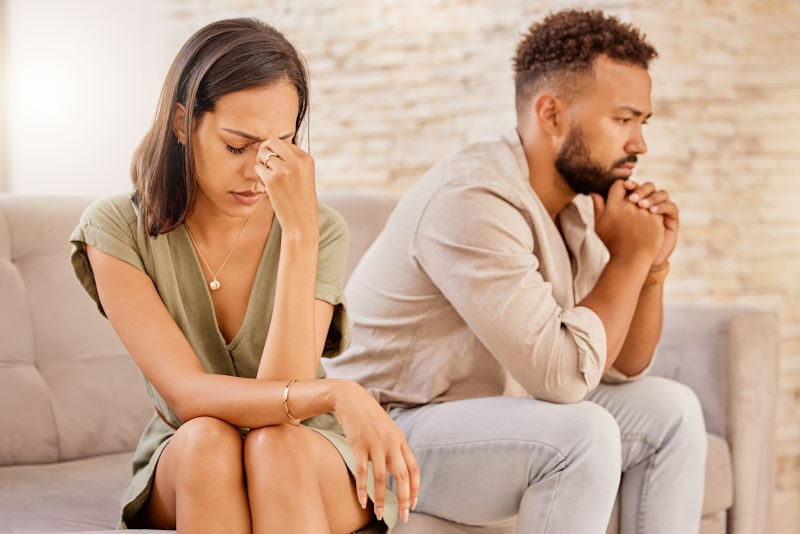 A man and woman going through counseling sitting on a couch.