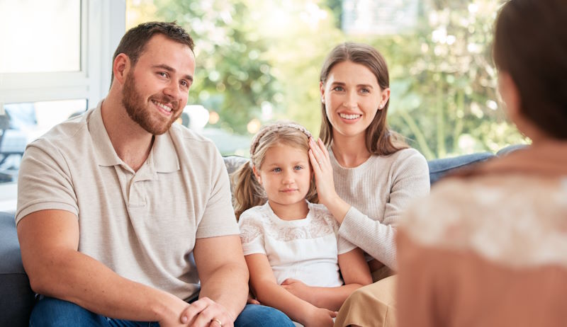 Image of a young family having a discussion with someone at home