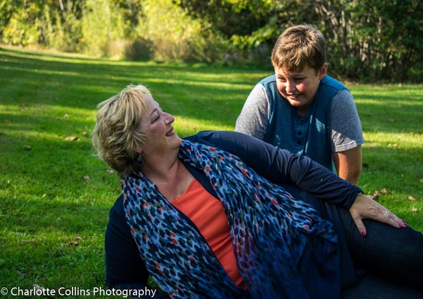 Picture of Stephie Collins with a child on the grass.